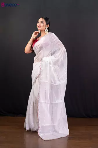 White jimmy choo saree adorned with intricate silver embellishments and a beautifully detailed border with ready blouse