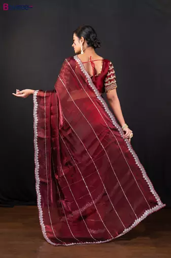 Maroon jimmy choo saree adorned with intricate silver embellishments and a beautifully detailed border with ready blouse