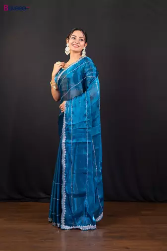 Blue jimmy choo saree adorned with intricate silver embellishments and a beautifully detailed border with ready blouse