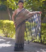 Cream saree with black stripes and blue prints on border and pallu
