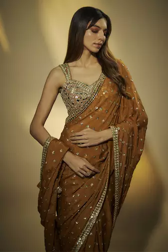 Copper chinnon chiffon sequins and mirror embroidered saree with mirror embroidered bustier .