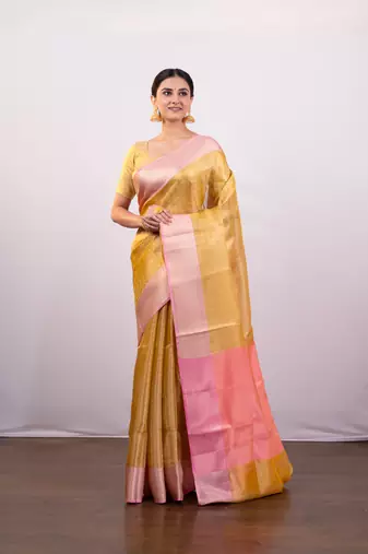 Gold tissue art silk saree with detailed pink zari border