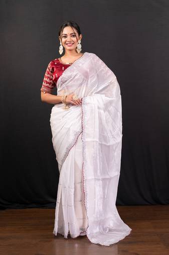 White jimmy choo saree adorned with intricate silver embellishments and a beautifully detailed border with ready blouse