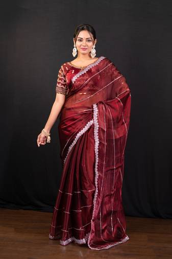 Maroon jimmy choo saree adorned with intricate silver embellishments and a beautifully detailed border with ready blouse