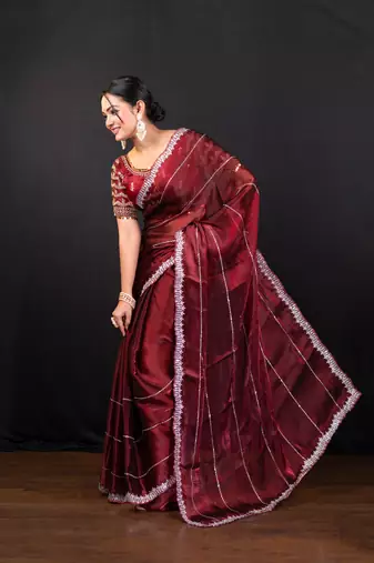 Maroon jimmy choo saree adorned with intricate silver embellishments and a beautifully detailed border with ready blouse