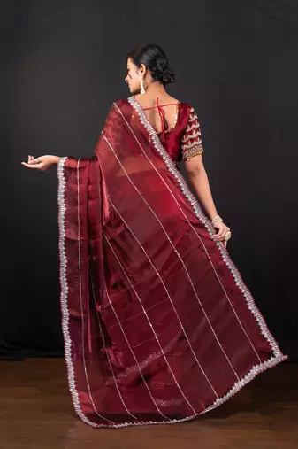 Maroon jimmy choo saree adorned with intricate silver embellishments and a beautifully detailed border with ready blouse