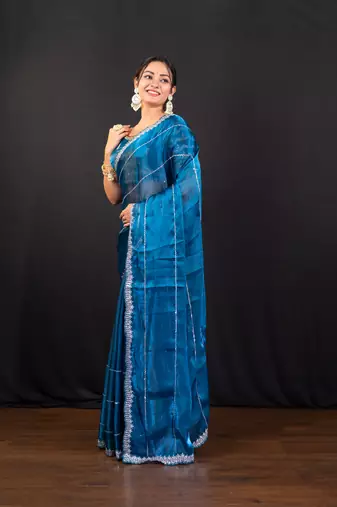 Blue jimmy choo saree adorned with intricate silver embellishments and a beautifully detailed border with ready blouse