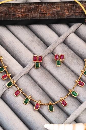 Gold-plated necklace and earrings set with red and green stones, ethnic indian jewellery