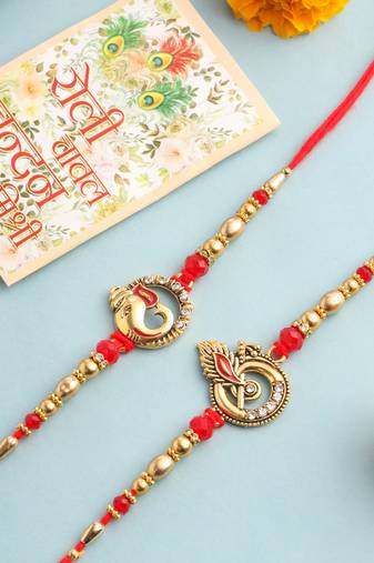   set of 2 golden red religious designer ganesh ji thread rakhi with roli chawal chandan & mishri