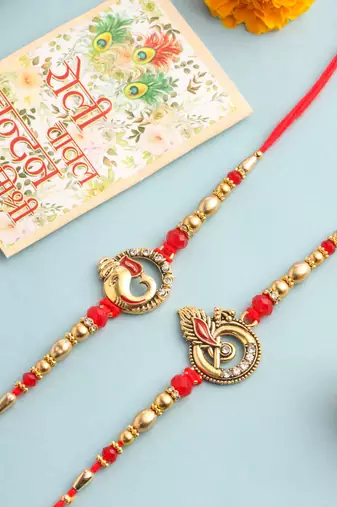   set of 2 golden red religious designer ganesh ji thread rakhi with roli chawal chandan & mishri