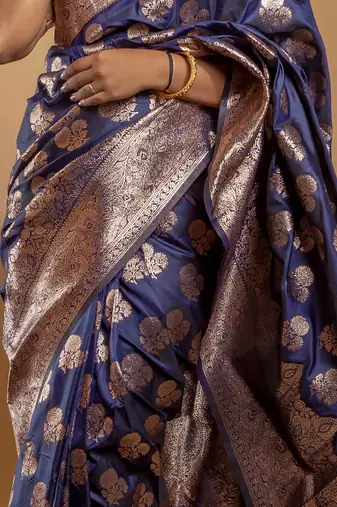 Navy blue zari woven saree with floral motifs and grand border