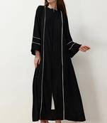 Black front open abaya in black firdaus with white piping and flared sleeves