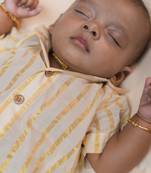 White cuban shirt romper with golden kasavu stripes and short sleeves.