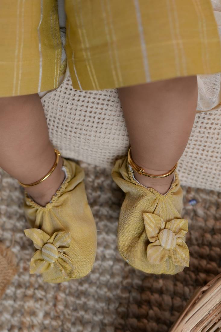 Yellow striped romper with headband and shoes.
