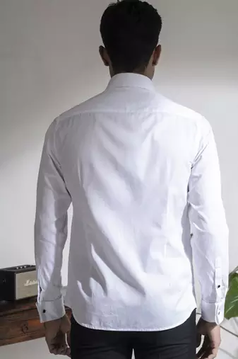 White plain cotton men's shirt with french cuffs and metal buttons.