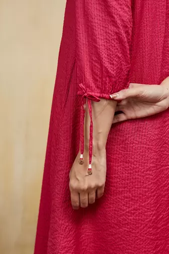 Pink plain cotton stripe kurti with tassel details.