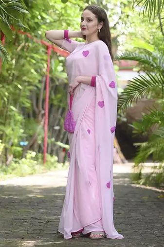 Pink plain georgette saree featuring heart motifs