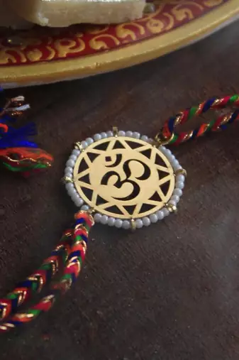 golden beaded om rakhi with roli chawal