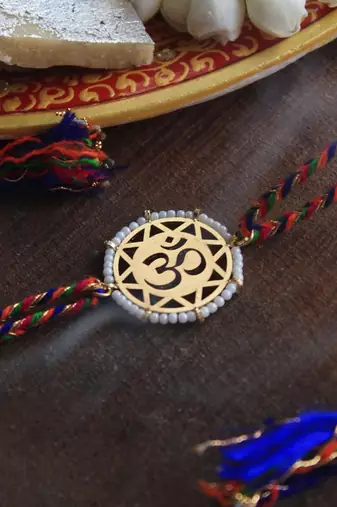golden beaded om rakhi with roli chawal