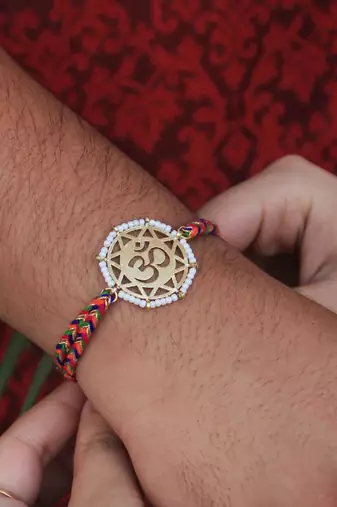 golden beaded om rakhi with roli chawal