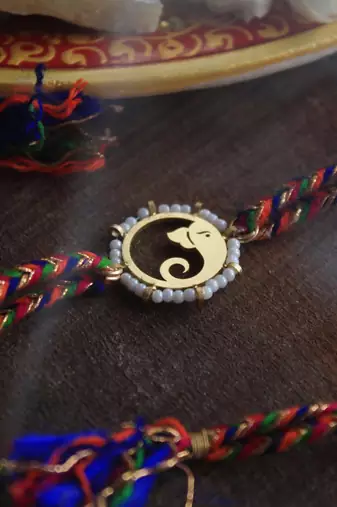 Golden beaded divinity rakhi with roli chawal