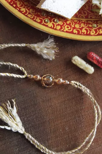 Gleaming beads rakhi with roli chawal