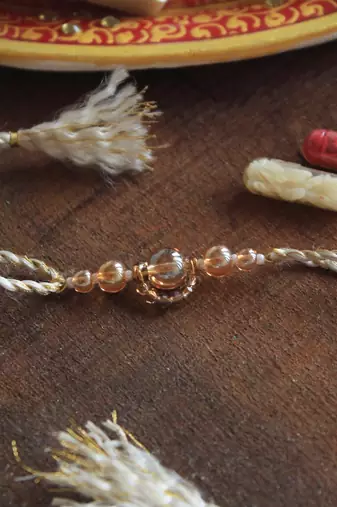 Gleaming beads rakhi with roli chawal