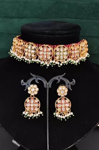 Elegant gold plated kundan choker necklace set with floral motifs, pearls, and matching earrings