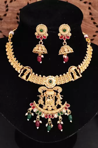 Temple jewellery rajwadi polish short necklace set with fancy design, red & green stones, and jhumka earrings.