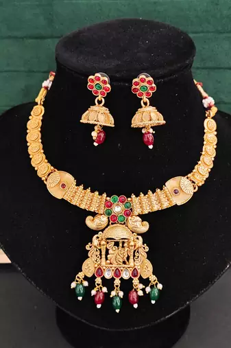 South indian jewelry necklace set with lakshmi pendant, ruby & green stones, coin design, and matching jhumka earrings