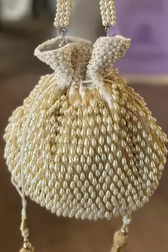 Adara ivory suede potli with pearl gold hanging
