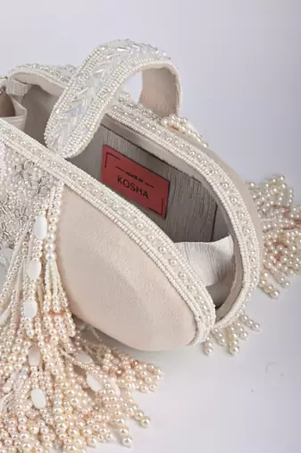 Azmat ivory suede embellished capsule bag