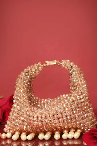 Gold potli bag with crystal work and pearl hangings