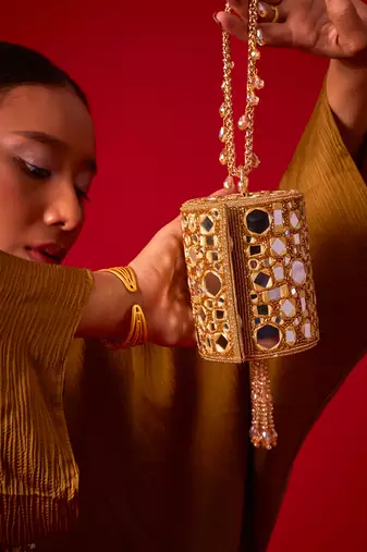 Gold satin potli bag adorned with mirror detailing