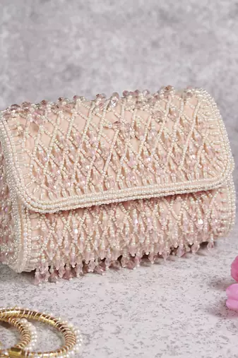 Pink suede clutch bag with a detachable pearl handle
