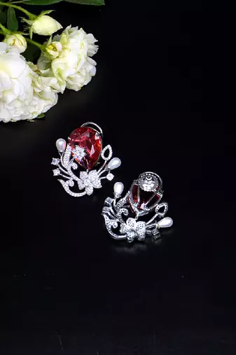 Floral-inspired stud earrings with teardrop centerpiece and pearl accents