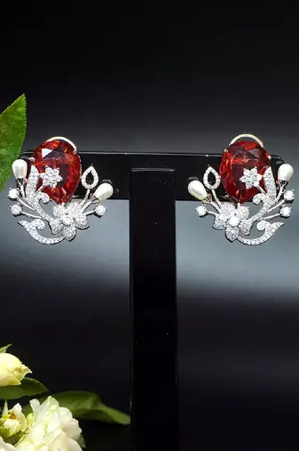 Floral-inspired stud earrings with teardrop centerpiece and pearl accents
