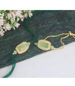 Mint green stone and crystal-studded unisex rakhi set for bhaiya bhabhi with roli chawal and written greeting note.