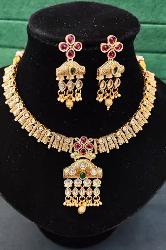 Traditional floral pendant necklace set with red and green stones and dangling beads