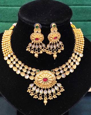 Beautiful gold-plated kundan necklace and earrings set with red and green stones, pearl accents for her 3