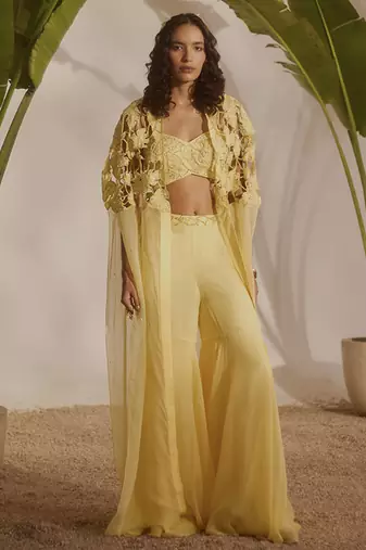 Yellow plain organza pant paired with embroidered blouse and cape