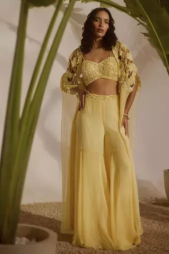 Yellow plain organza pant paired with embroidered blouse and cape