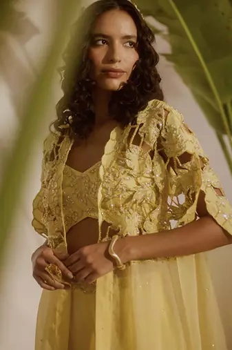 Yellow plain organza pant paired with embroidered blouse and cape