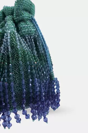 Emerald green potli bag embellished with crystal fringes and a drawstring