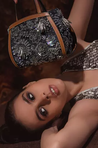 Silver embroidered bead-embellished clutch bag with crossbody strap.