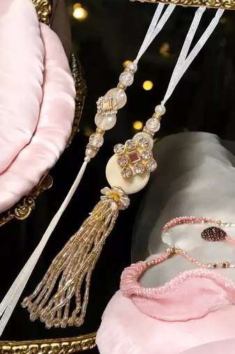 Traditional crystal & pearl rakhi – beautiful gold tassel design for brother and bhabhi