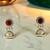 Golden glamour antique jhumka earrings with green stone & pearl detailing