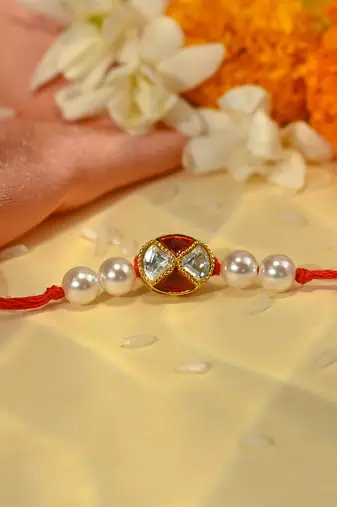 Red thread rakhi with oval dual stone charm and pearl beads