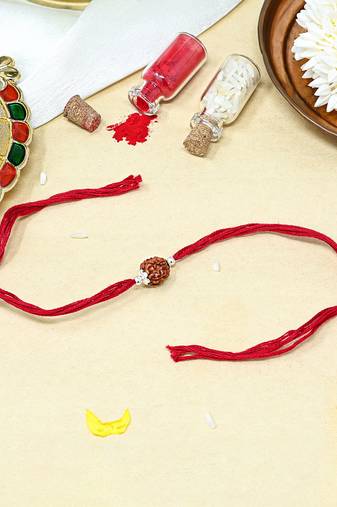 Red thread rakhi with single rudraksha bead and silver accents