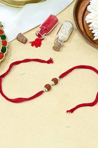 Red thread rakhi with dual rudraksha beads and silver details
